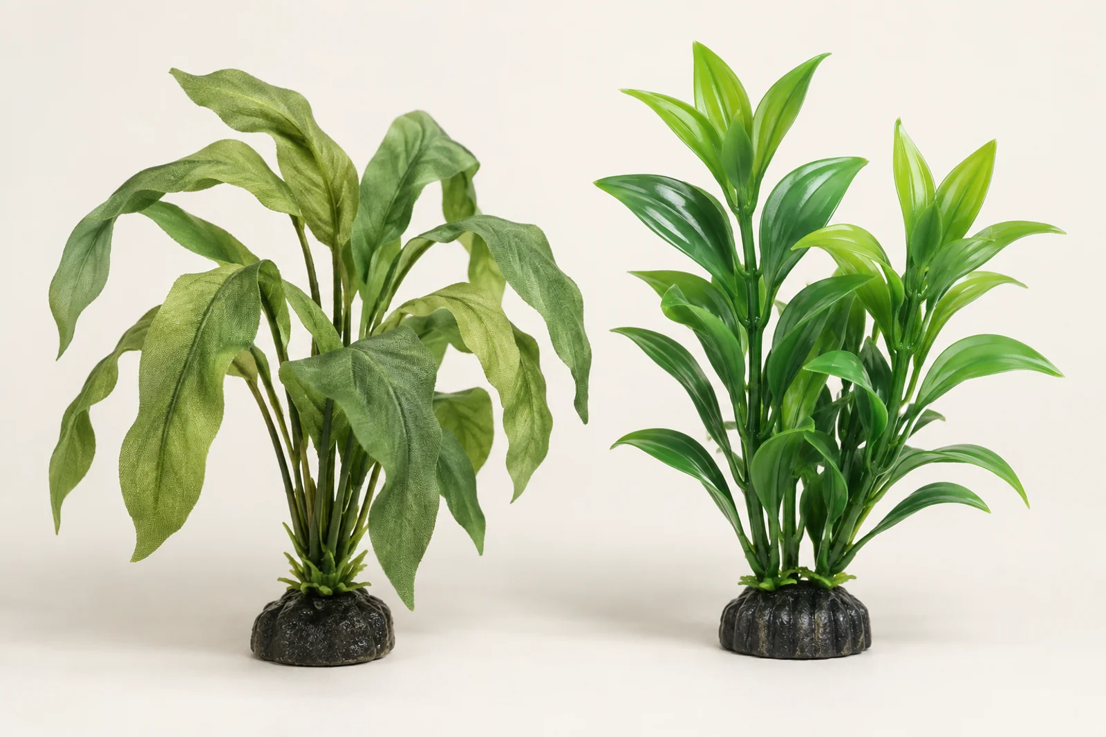 A soft fabric silk aquarium plant and a rigid moulded plastic plant standing side by side against a plain background